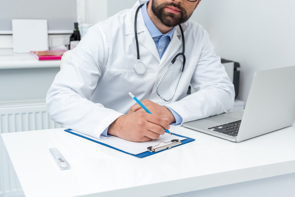 doctor writing in clipboard - Photo, Image