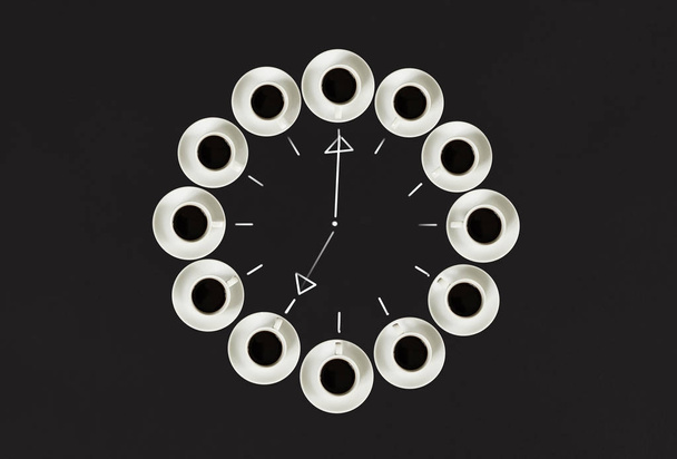 Tazas con café, apiladas en círculo. Reloj consisten en veinte tazas. Fondo negro. Concepto tiempo para el café
 - Foto, imagen