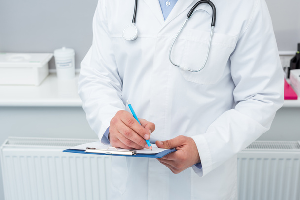 doctor writing in clipboard - Photo, Image