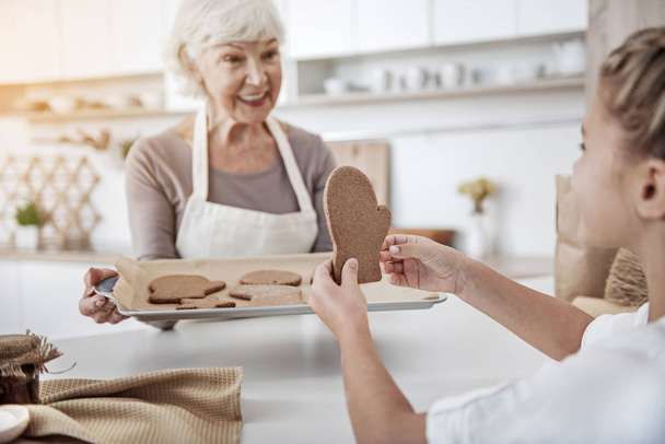 Happy grandmother treating kid with sweet pastry - Photo, Image