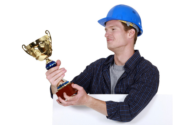 Proud builder holding trophy - Foto, afbeelding