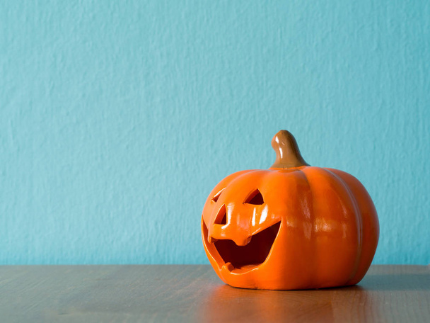 Halloween dýně hlava na dřevěný stůl. na pozadí je modrá a copyspace pro text - Fotografie, Obrázek