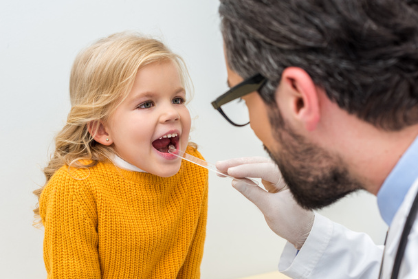 pediatrist checking throat of little girl - Fotó, kép