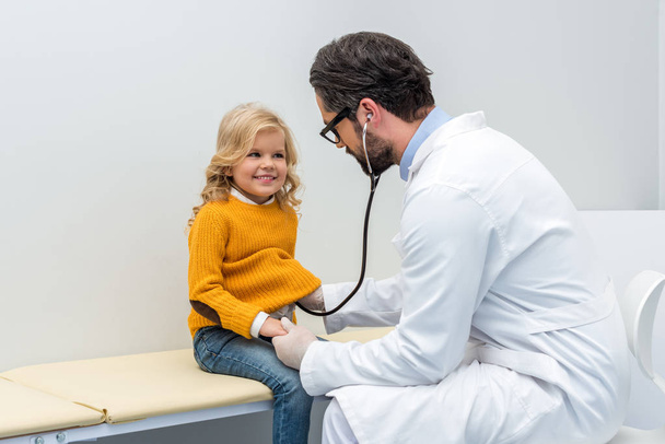pediatrist listening to breath of little girl - Fotó, kép