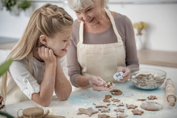 Cheerful granddaughter learning how to bake pastry - Valokuva, kuva
