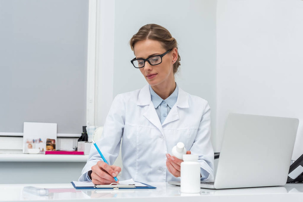 female doctor writing in clipboard - Photo, image