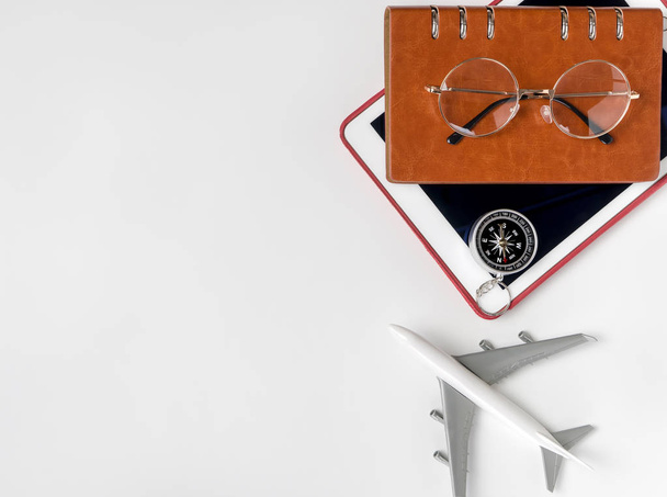 αντικείμενα ταξιδιού και παιχνίδι αεροπλάνο σε άσπρο φόντο για ταξίδια έννοια - Φωτογραφία, εικόνα