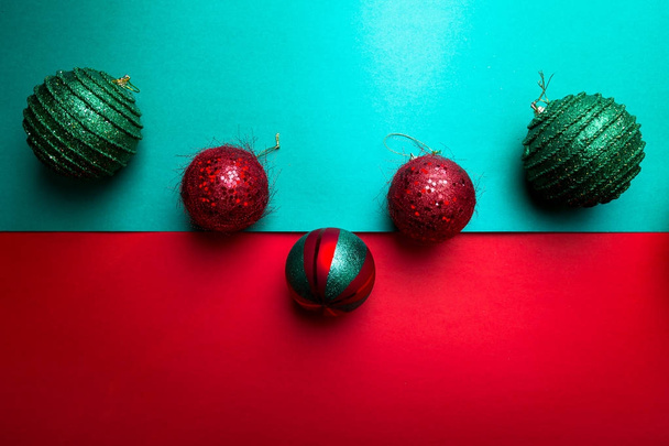 Χριστουγεννιάτικη μπάλα στο backround πράσινο και κόκκινο πιπέρι. Χριστούγεννα ευχετήριας κάρτας. Καλά Χριστούγεννα. Το Top view. Αντιγράψτε το χώρο. Έννοια του μινιμαλισμού.  - Φωτογραφία, εικόνα
