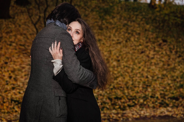 couple hugs in a fall park. Golden Autumn on the background with leaves and trees, foliage. - Foto, Imagem