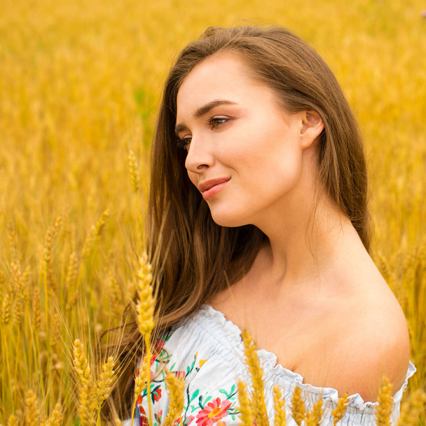 Young woman on a background of golden wheat field - Foto, Imagem