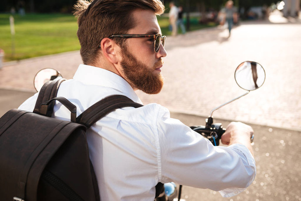 Вид сзади Крутой бородатый мужчина в солнечных очках с рюкзаком
 - Фото, изображение
