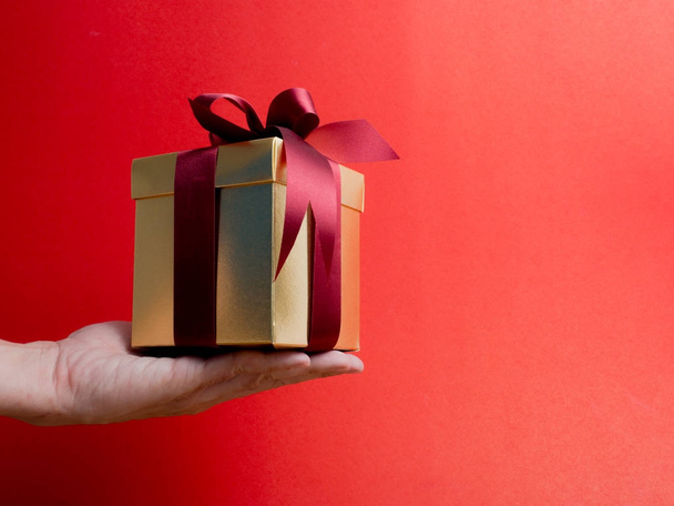 Valentinstag, Neujahr goldene Geschenkbox mit roter Schleife. rot - Foto, Bild