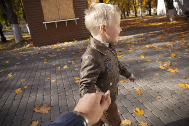 Utánam, gyönyörű kisfiú tart egy apa keze - Fotó, kép
