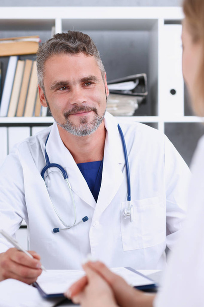 Smiling handsome mature doctor communicate with patient - Photo, image