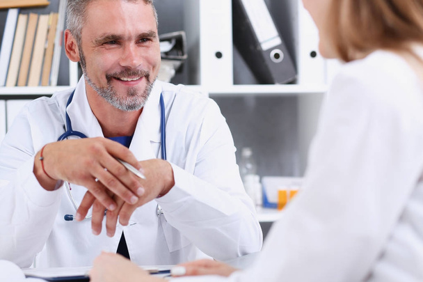 Sorridente bel medico maturo comunicare con il paziente
 - Foto, immagini
