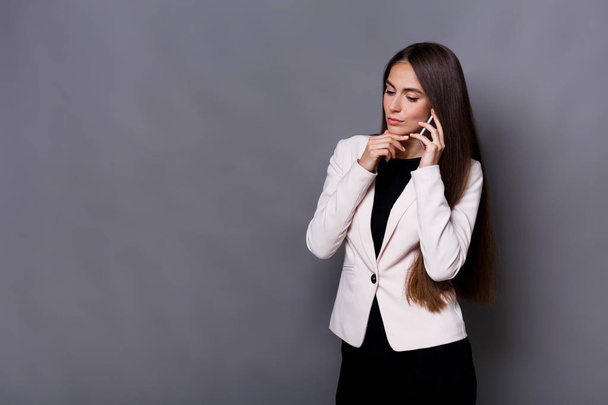 Young caucasian businesswoman studio shot on grey background - Фото, зображення