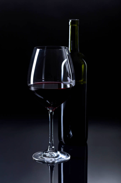 Glass and bottle of red wine. - Foto, afbeelding
