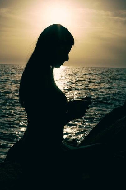 Splendida donna che tiene il vino al tramonto  - Foto, immagini