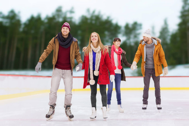 friends holding hands on outdoor skating rink - Φωτογραφία, εικόνα
