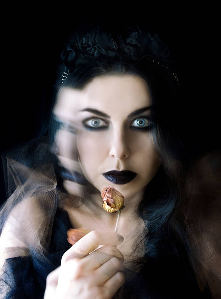 tmavé vlasy gothic girl s černými rty a suchou růže v ruce - Fotografie, Obrázek