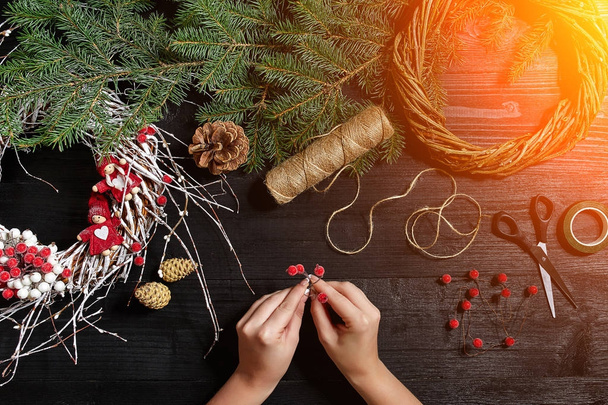 Κατασκευαστής του ντεκόρ Χριστουγέννων με τα χέρια τους. Χριστουγεννιάτικο στεφάνι για τις διακοπές. Εορτασμό του νέου έτους. Το Top view. Ήλιος φωτοβολίδα - Φωτογραφία, εικόνα