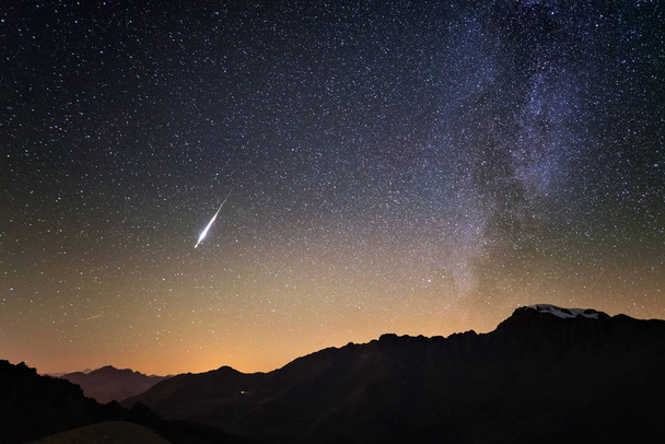 Milky Way and starry sky from high up on the Alps. Real Christmas comet in the sky. Majestic high mountain range with glacier and snow. - Photo, Image