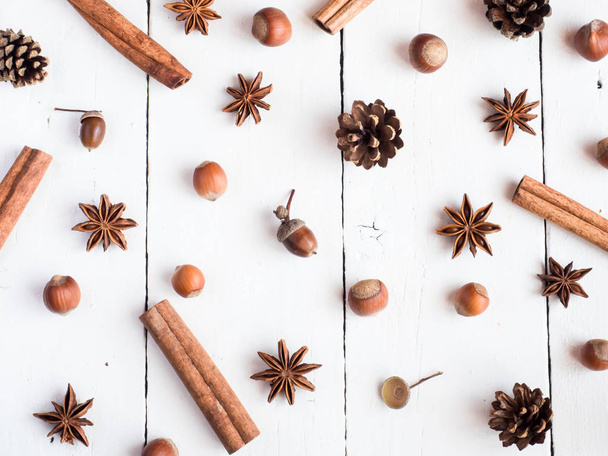 Cinnamon sticks spice star fir cones on white wooden background Flat lay - Foto, immagini