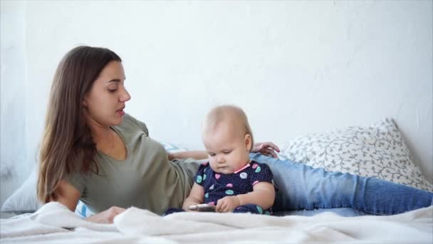 attraktive Mutter liegt mit ihrer Tochter im Bett. - Filmmaterial, Video