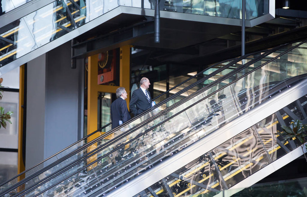 Business people on the  escalator. City of London office building entrance - Фото, изображение