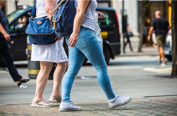 Feet of pedestrians walking on the crosswalk in Oxford street, London. Modern life, travel and shopping concept - Fotó, kép