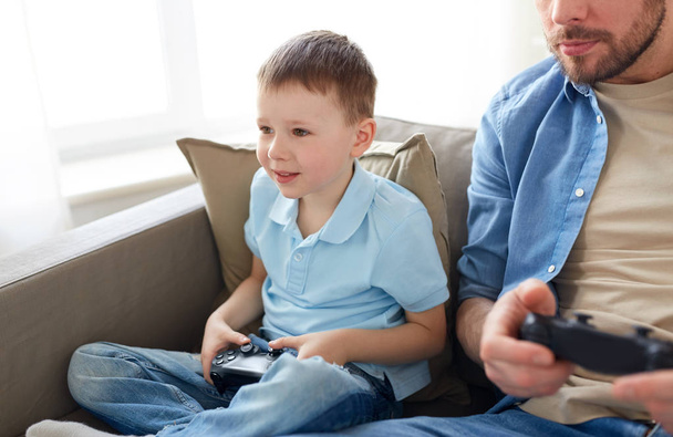father and son playing video game at home - Photo, Image