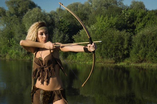 Wild amazon girl shoots from the bow. - Photo, Image