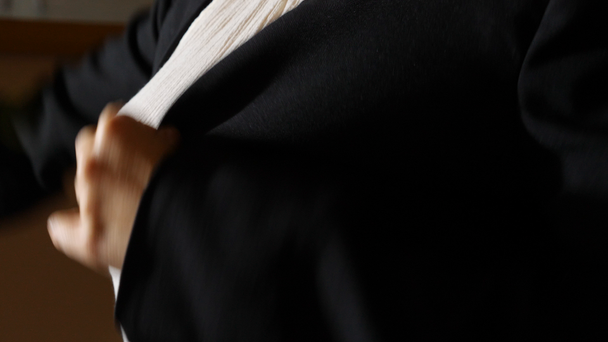 Kobieta z piękną skrzynię stawia na czarna kurtka. 4k, zwolnionym tempie - Materiał filmowy, wideo