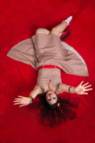Luxus lány pózol, piros ágyon - Fotó, kép