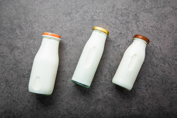 Milchflasche auf dunklem Steinhintergrund. Ansicht von oben mit Kopierraum. - Foto, Bild
