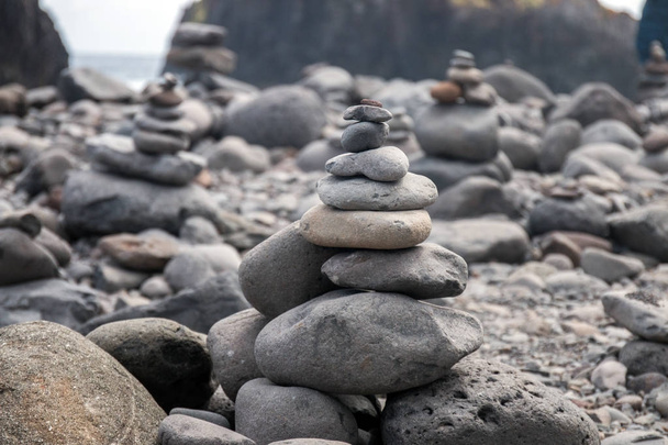 Tasapainoiset kivet rannalla
 - Valokuva, kuva