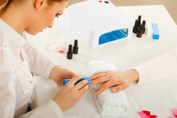 Woman getting manicure done file nails - Фото, изображение