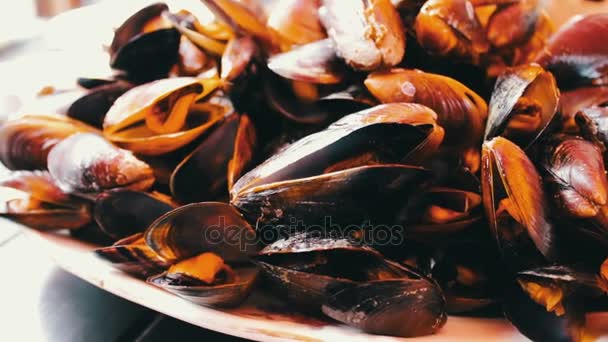 Delicious freshly prepared mussels lie on plate on a table in a restaurant - Footage, Video