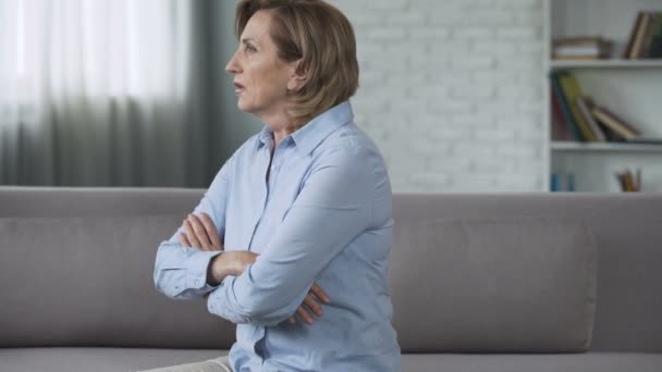 Senior woman sitting on couch, feeling depressed, psychological problems, crisis - Кадри, відео