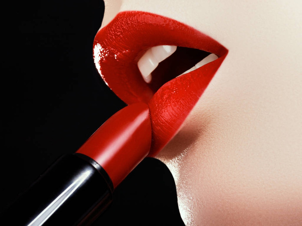 Cosmetics and makeup. Perfect lip makeup. Fashion model applying lipstick. Beautiful young woman - Photo, Image