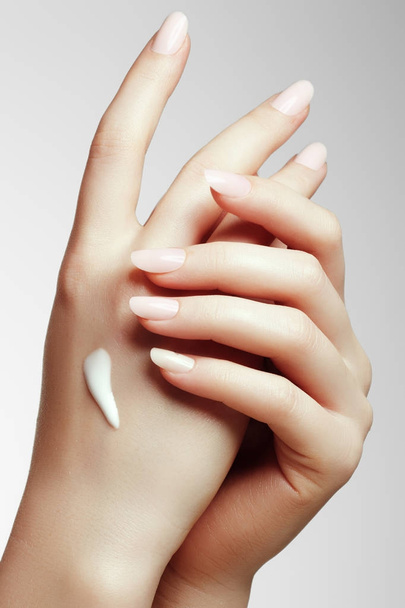Young woman putting cream on her hand - Photo, Image
