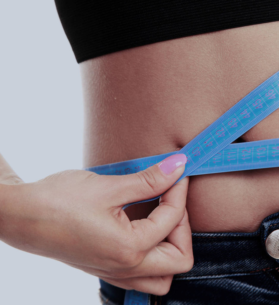 woman measuring the thickness of her fat. - Valokuva, kuva