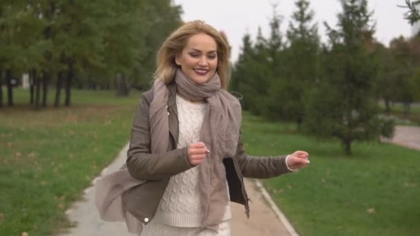 όμορφη ξανθιά κοπέλα περπάτημα στο πάρκο - Πλάνα, βίντεο