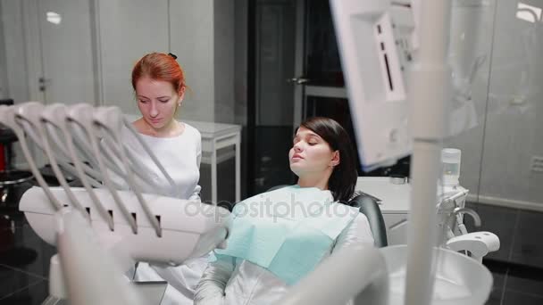 Ο οδοντίατρος ολοκληρώνει το έργο του με έναν ασθενή. Αφαιρεί Bor μηχανή και δίνει ένα κορίτσι έναν καθρέφτη για να αξιολογήσει το έργο. Το κορίτσι φαίνεται τα δόντια σας και ευχαρίστησε τον οδοντίατρο. - Πλάνα, βίντεο