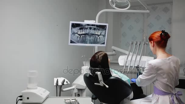 El dentista completa su trabajo con un paciente. Elimina la máquina Bor y le da a una chica un espejo para evaluar el trabajo. La chica te mira los dientes y agradece al dentista
. - Metraje, vídeo