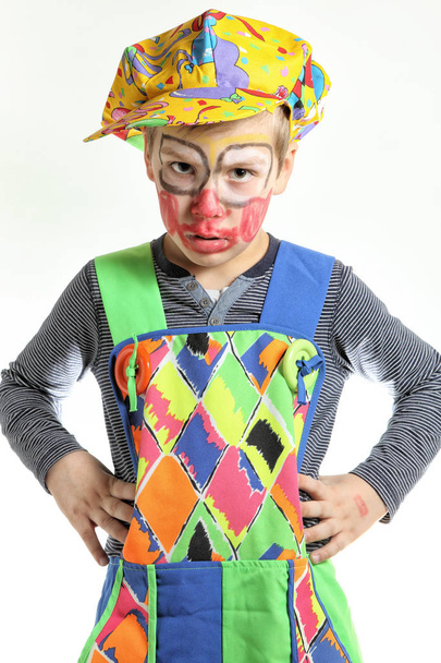 Klovni poika kädet akimbo ja maalattu kasvot
 - Valokuva, kuva