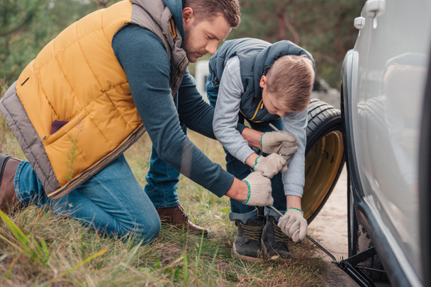 Father and son changing car wheel - Photo, image