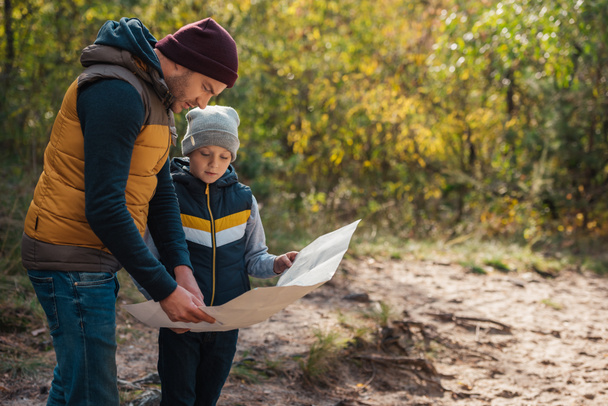 father and son with map in forest - Photo, Image