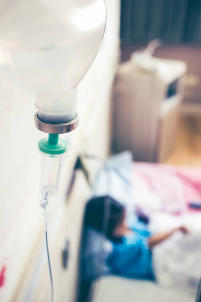 Enfermedad chica asiática sentada en la cama enferma en el hospital con goteo intravenoso IV
. - Foto, Imagen