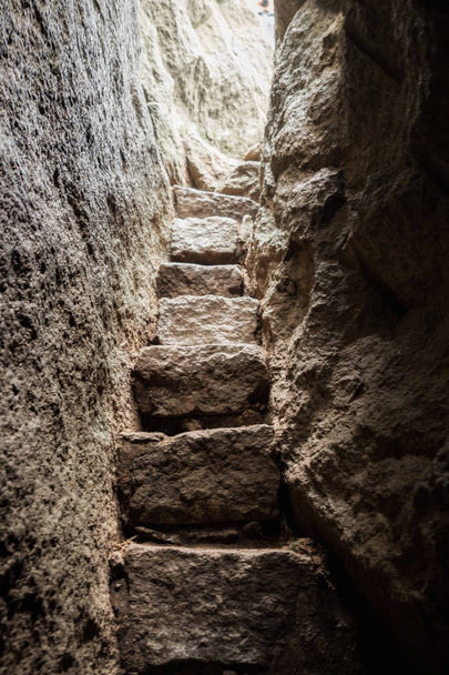 Escalera estrecha de piedra en roca
 - Foto, imagen